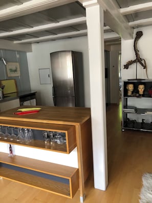 A modern kitchen with a wooden island, stainless steel refrigerator, and a glass display cabinet. - The historic town of Laupen near Bern—Top-Notch Apartment on the 1st Floor (Laupen)