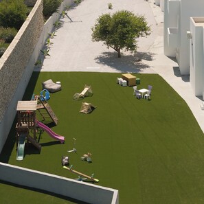 A children's play area with a slide, swings, and a small climbing structure. - Ariselia Villa, Grand Spaces, Wellness & Play (Retymno)