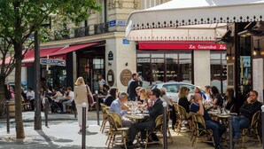 An outdoor café with tables and chairs, surrounded by buildings and trees. - 1BR with Eiffel Tower View - Near Arc de Triomphe (Paris)
