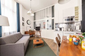 Ein modernes Wohnzimmer mit einer Couch, einem Couchtisch und einem Essbereich mit Frühstücksangeboten.
