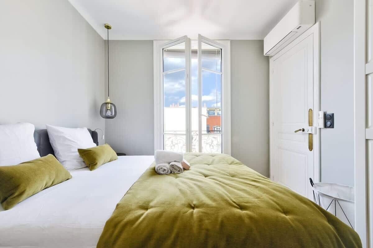 Ein Hotelzimmer mit Bett, Fenster und Tür.