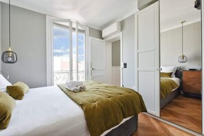Ein Hotelzimmer mit Bett, Schrank, Spiegel und Fenster mit Aussicht.
