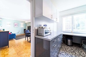A modern kitchen with a microwave, a trash bin, and a window. - Calm & Central - Seine Musicale - Near Paris (Sèvres)
