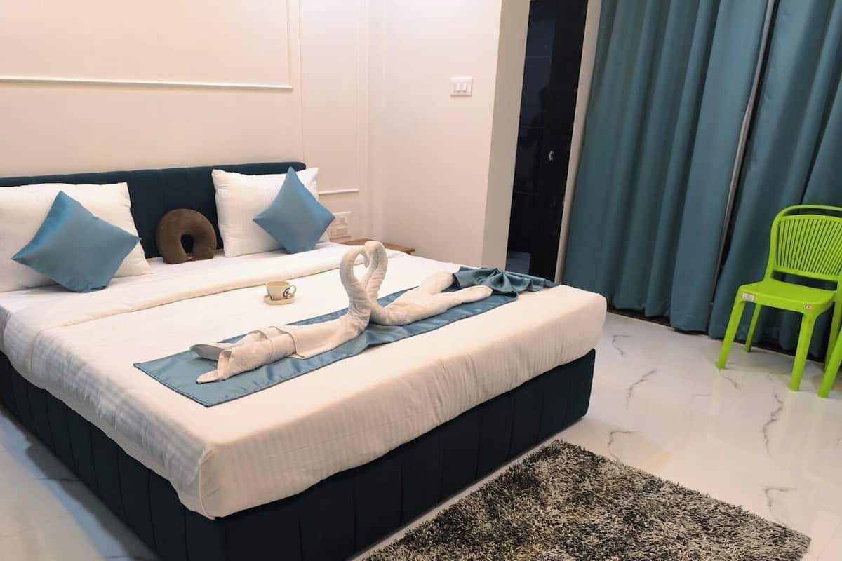 A neatly made bed with pillows, a towel, and a blanket.