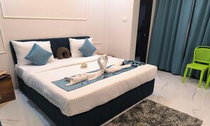 A neatly made bed with pillows, a towel, and a blanket. - Lexis Inn Beach Resort (Diveagar)