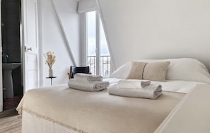 Ein modernes Schlafzimmer mit einem großen Bett, zwei Kissen und zwei gefalteten Handtüchern.