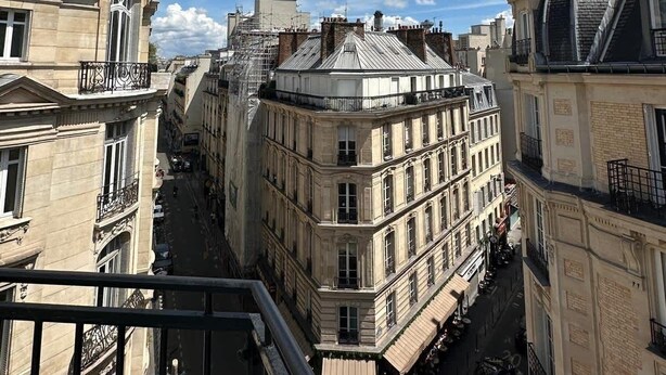 Katunäkymä, jossa näkyy rakennuksia, mukaan lukien kupolilla varustettu rakennus ja parvekkeellinen rakennus.
