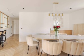 A modern dining area with a round table, chairs, and a vase with flowers. - Luxury & spacious near Accor Arena & Bastille (Charenton-le-Pont)