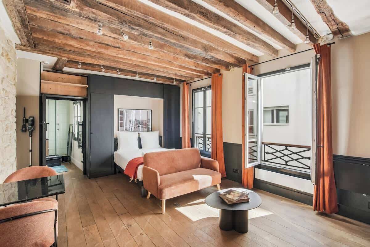 Un interior moderno con techo de madera, un sofá, una mesita y vistas al exterior.