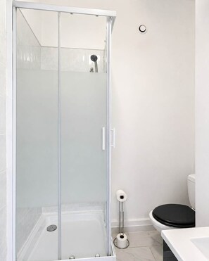 Ein modernes Badezimmer mit Duschkabine, Toilette und Waschbecken.
