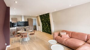 A modern living room with a sofa, round coffee table, and dining area with chairs. - Historic Stay in Medemblik | Tesstays (Medemblik)