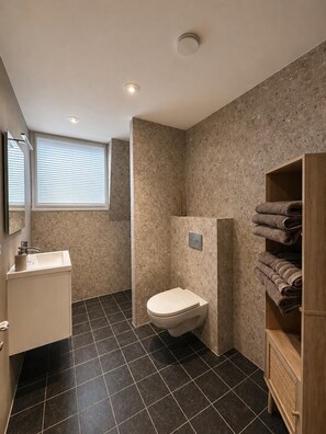 Ein Badezimmer mit Toilette, Waschbecken und Handtuchhalter.