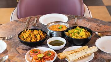 A table with various dishes, including rice, a bowl of soup, and a plate of sliced onions.