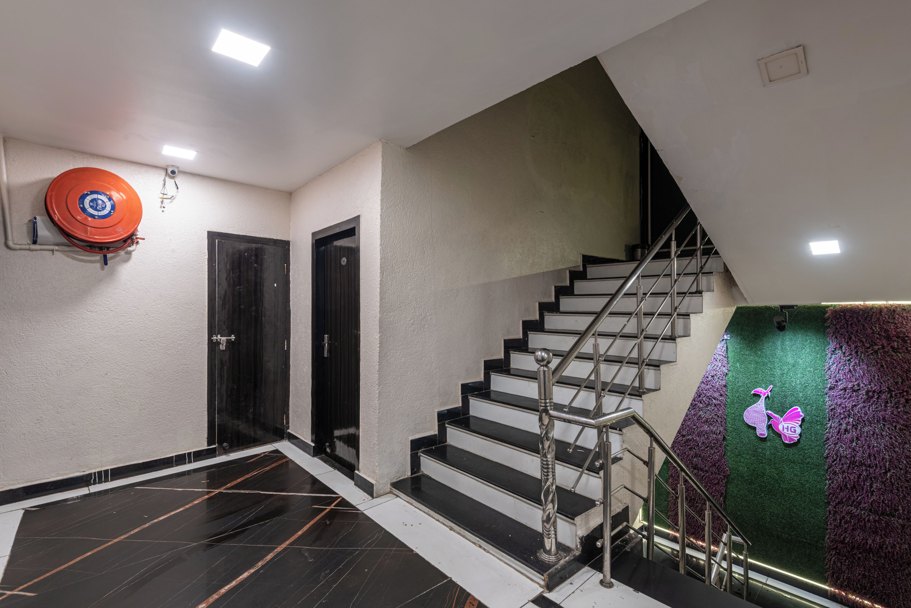 A staircase with a metal railing and a wall-mounted fire extinguisher.