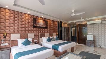 A hotel room with two beds, a large painting, a ceiling fan, and a marble floor.