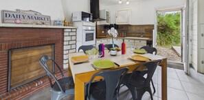 A dining area with a brick fireplace, a microwave, and a kitchen counter. - House with pool & large garden overlooking horses (Angles)