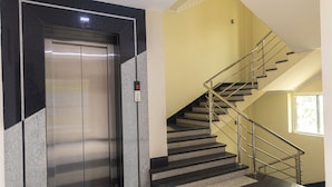 Un ascensor y una escalera con barandillas metálicas.