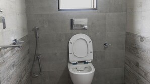 Un baño pequeño y moderno con inodoro, ducha y ventana.