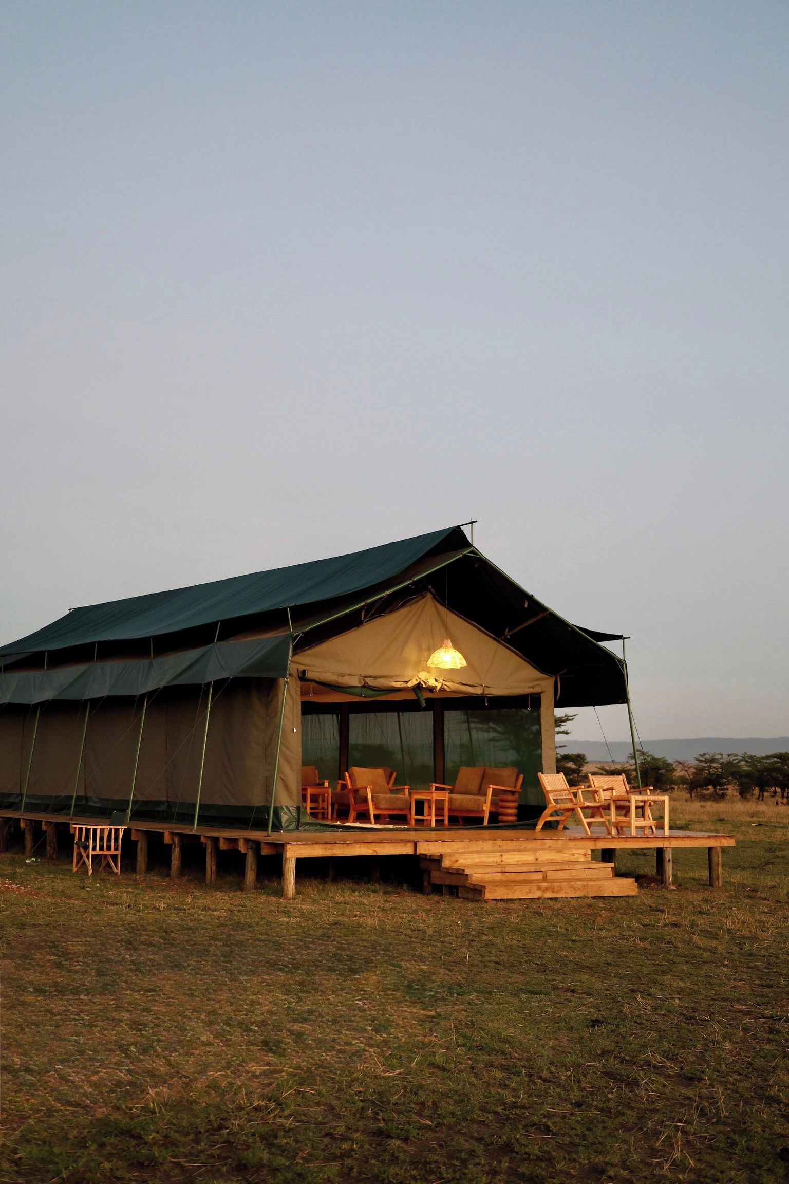 Acomodação em tenda com área de estar coberta e uma mesa.