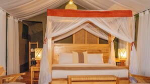 A wooden four-poster bed with white bedding and a red and black checkered canopy. - Amani Lamai Luxury Camp (Nyanungu)
