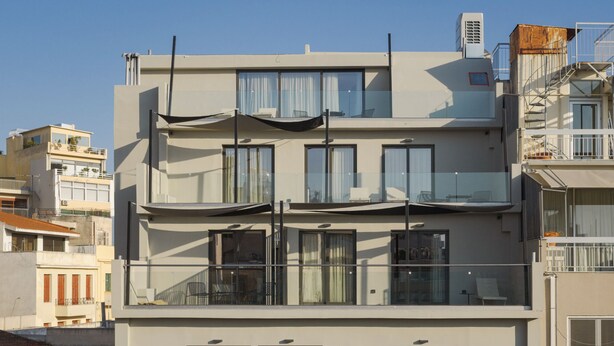 A multi-story building with balconies, large windows, and a flat facade.