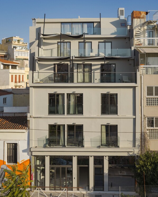 Un edificio de varios pisos con balcones, ventanas amplias y fachada plana.