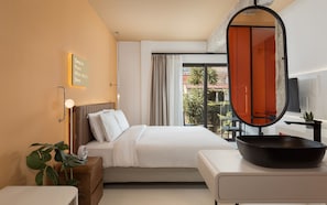 A hotel room with a bed, bedside table, a mirror, a window with curtains, and a view of the outside. - Noctilia Athens (Athens)