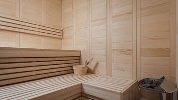 A wooden sauna with benches and a small bucket.