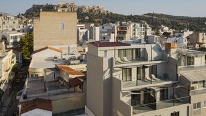 A modern urban landscape with a mix of residential and commercial buildings, featuring flat-roofed structures and a prominent historical site in the background.