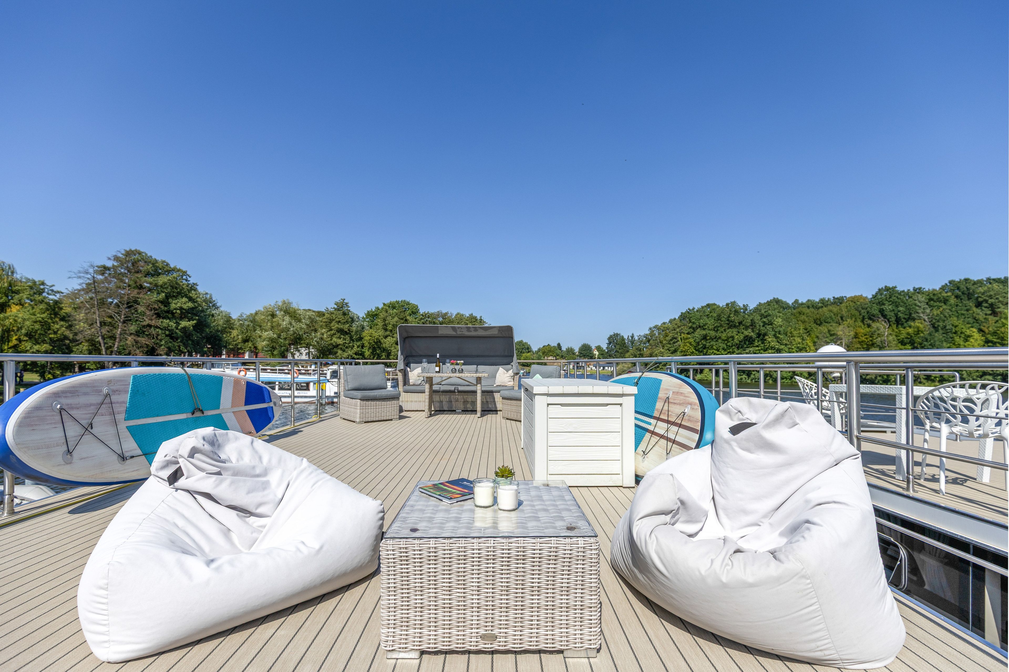 Eine Terrasse mit Sitzgelegenheiten, einem Tisch und einem Fernseher.