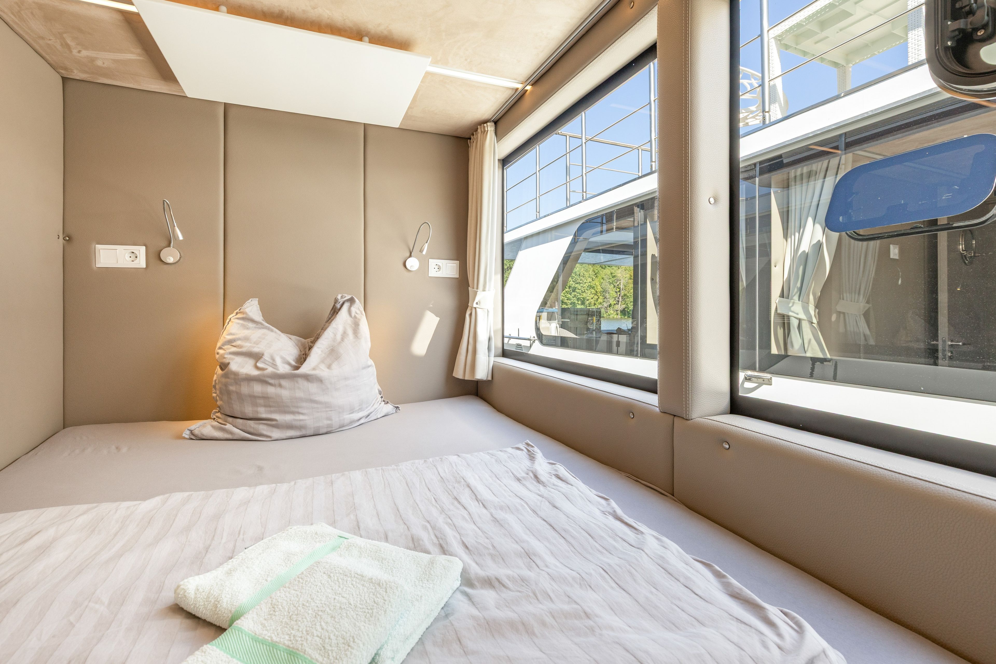 Ein kleines Zimmer mit einem Bett, einem Fenster und Blick nach draußen.