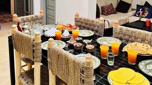 Ein Essbereich mit einem Tisch, der für das Frühstück gedeckt ist, einschließlich Teller, Gläsern und einer Flasche.