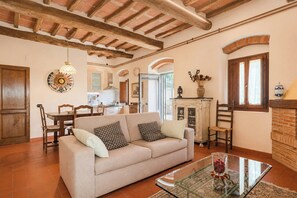 A living room with a sofa, a glass coffee table, and a fireplace. - Independent villa among Chianti vineyards (Greve in Chianti)