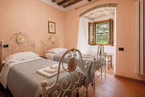 Um quarto com duas camas, uma janela com vista e uma porta.