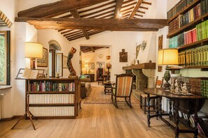 A cozy library with wooden bookshelves, a fireplace, and a comfortable seating area. - Independent villa among Chianti vineyards (Greve in Chianti)