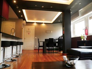 A modern interior with a dining area, bar stools, and a clear view of the kitchen.