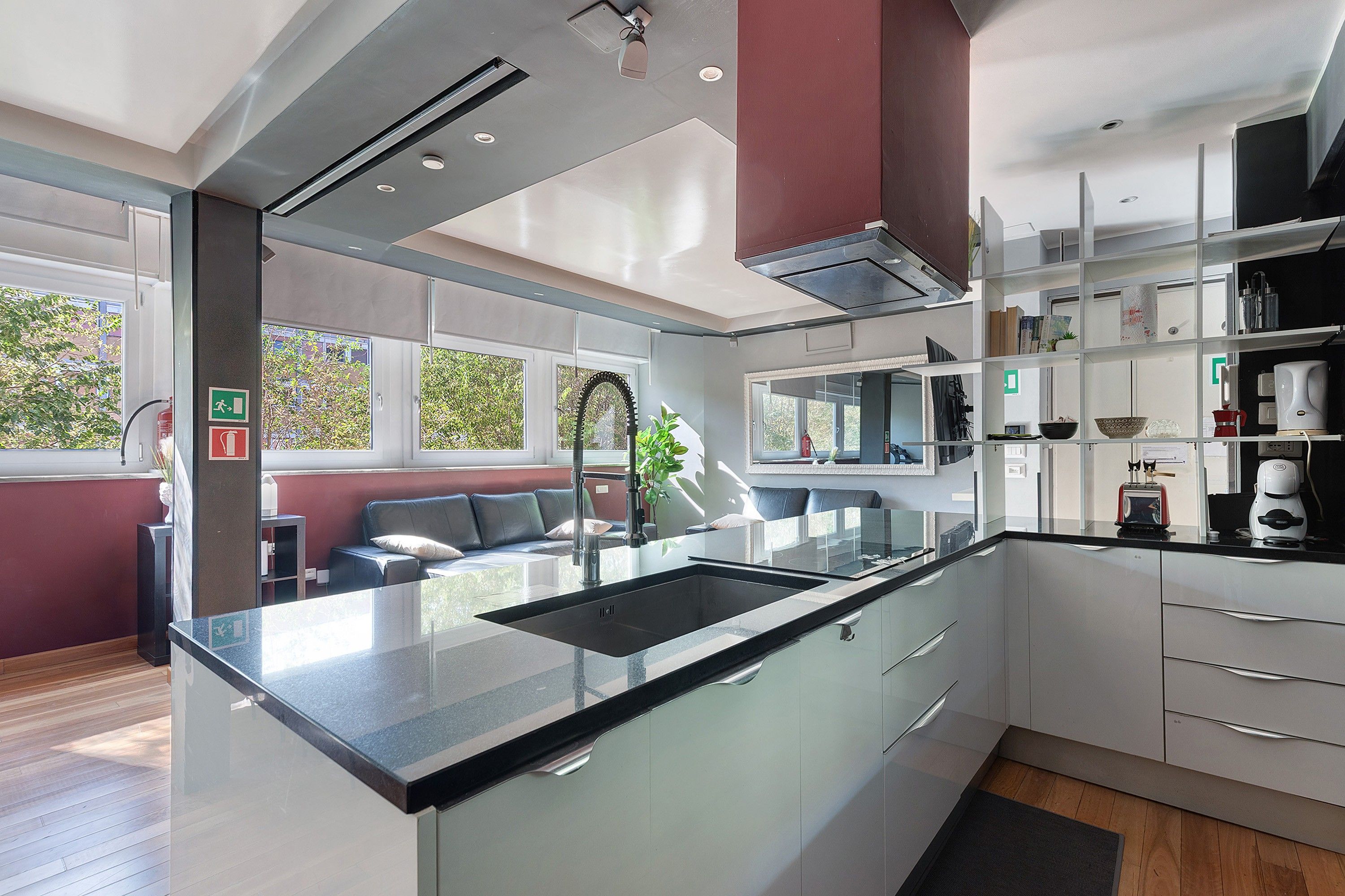 Una cucina moderna con un piano di lavoro nero, elettrodomestici in acciaio inossidabile e forno integrato.