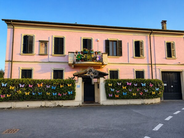 Un edificio rosa con numerose finestre e un ingresso centrale.