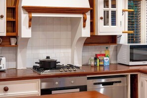 A kitchen with a stove, microwave, and various kitchen appliances.