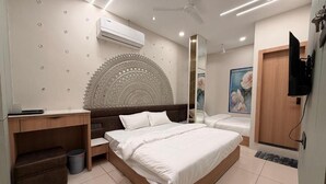 Ein modernes Schlafzimmer mit einem großen Bett, einem Schreibtisch und einem Fernseher.