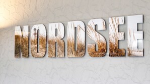 Una pared con la palabra 'NORDSEE' en letras metálicas grandes.