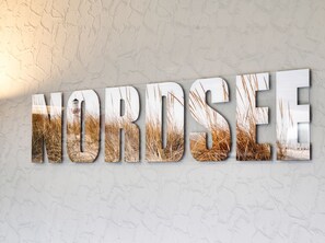 A wall with the word 'NORDSEE' in large, metallic letters. - Ankertied: Your cozy vacation apartment in Büsum, near the sea (Büsum)