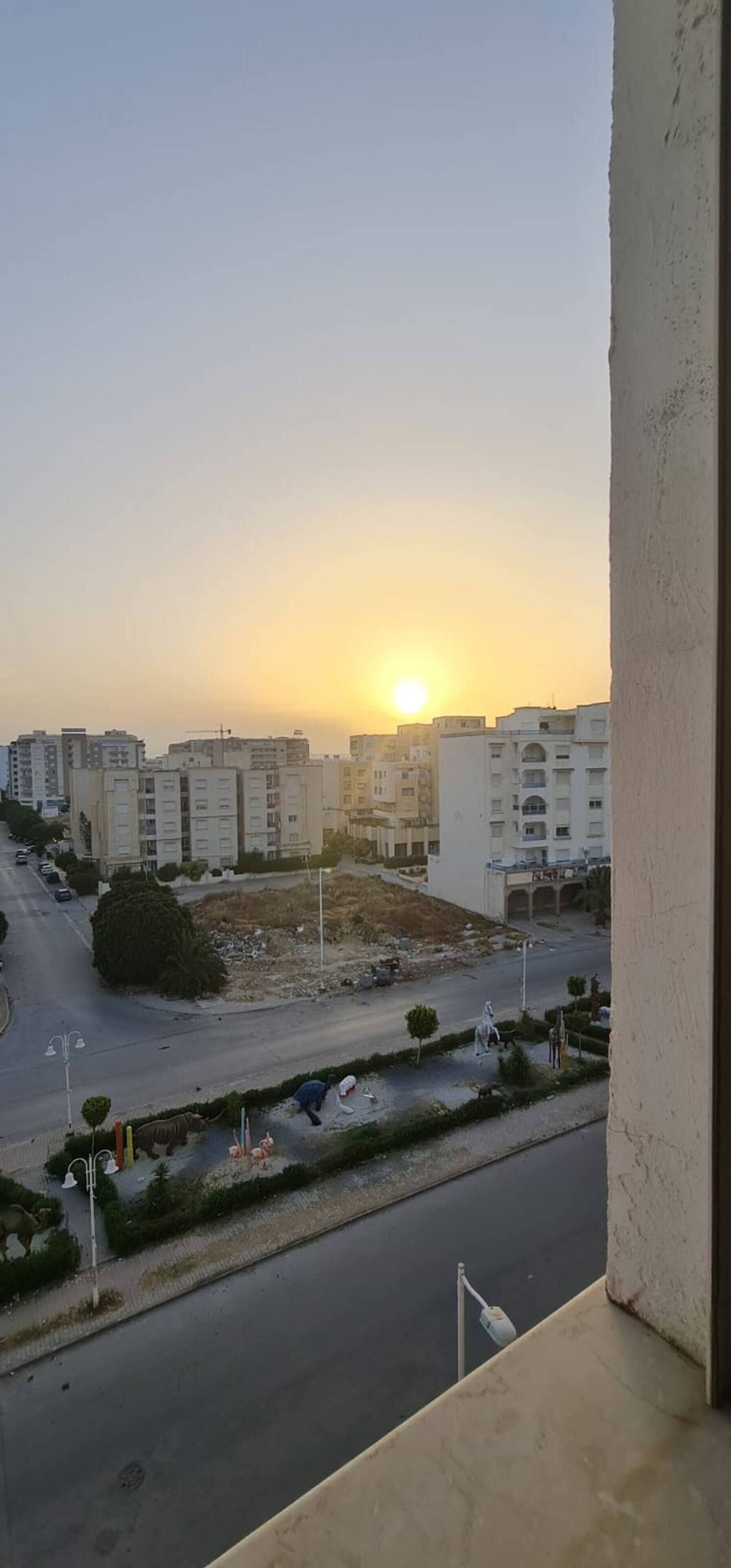 Zona residencial con edificios y una calle al atardecer.
