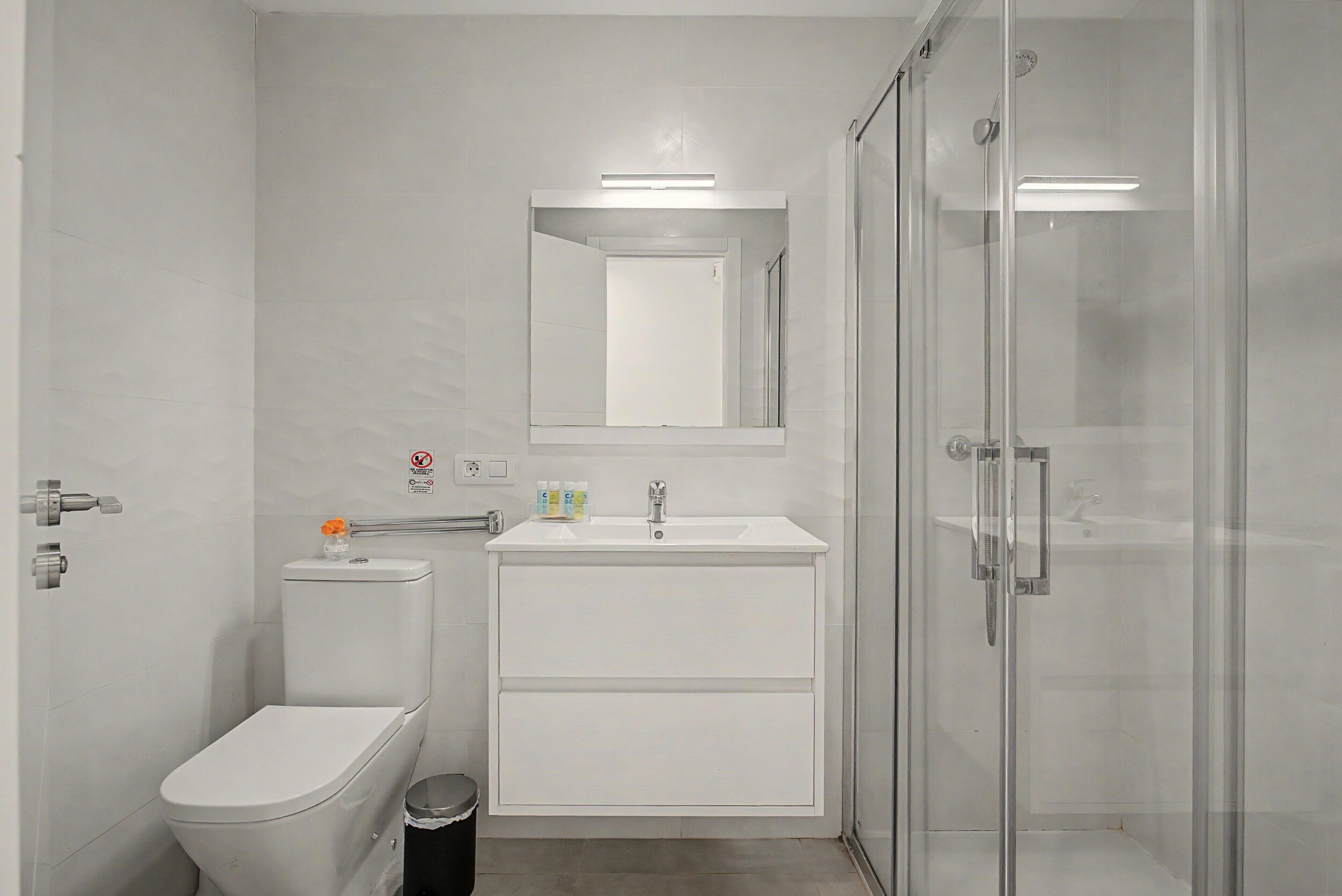 Un bagno moderno con il water, un lavandino e una cabina doccia in vetro.