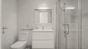 Un bagno moderno con il water, un lavandino e una cabina doccia in vetro.