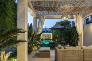 A covered outdoor area with a pool, seating, and a pergola. - Hestia Grey Barefoot Escape 100m From Beach (Rethymno)