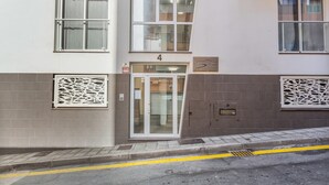 A building with a numbered entrance, a fire alarm sign, and a security intercom. - Vacation Apartment 'Brisa A. Apto En El Médano' with Wi-Fi and Air Conditioning (El Médano)