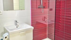 A modern bathroom with a glass shower enclosure, a white sink, and a mirror. - Studio Apartment 'Ofis - Estudio Morado' with Wi-Fi and Air Conditioning (Conil de la Frontera)