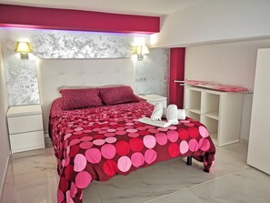 Ein Schlafzimmer mit Bett, Nachttischen, einem Kleiderschrank und einem Wandregal.