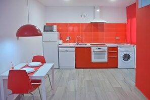 Eine kleine Küche mit Mikrowelle, Spüle und Waschmaschine.